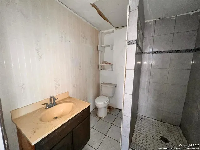 a bathroom with a granite countertop sink toilet and shower