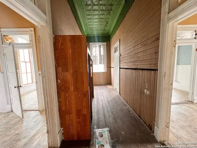 a view of a hallway with wooden floor and stairs