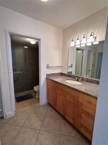 a spacious bathroom with a granite countertop sink mirror and shower