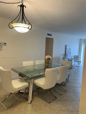 a living room with a table chairs and a wooden floor
