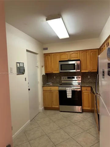 a kitchen with stainless steel appliances granite countertop a stove a microwave and a refrigerator