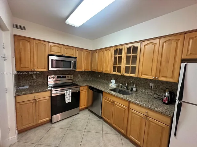 a kitchen with stainless steel appliances granite countertop a sink stove and microwave