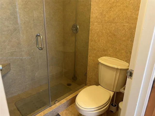 a white toilet sitting next to a bathroom