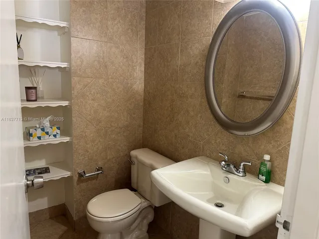 a bathroom with a sink a toilet and a mirror