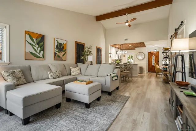 a living room with furniture kitchen view and a flat screen tv