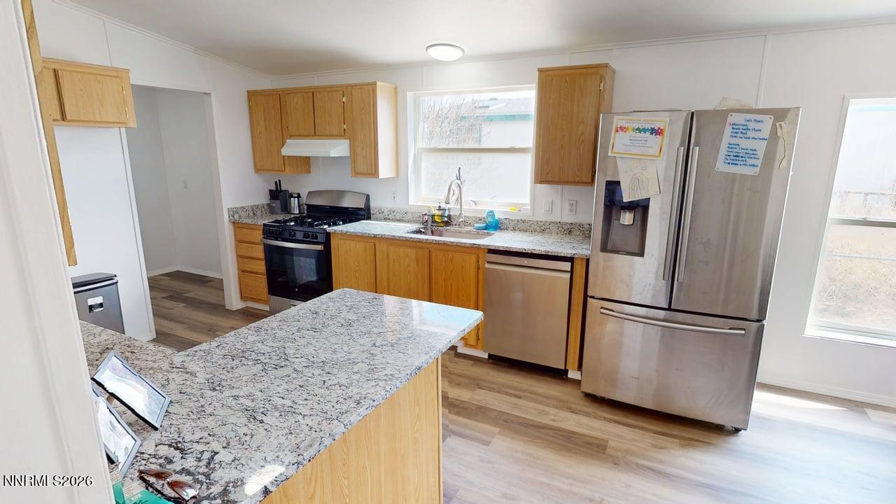 102 Bastian Road Battle Mountain, NV 89820 - Photo 16 of 38 a kitchen with stainless steel appliances granite countertop a refrigerator sink and stove
