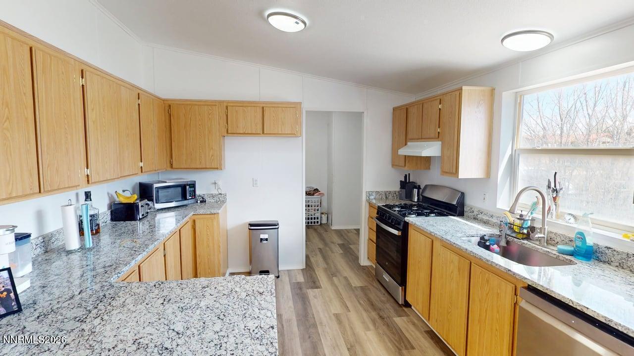 102 Bastian Road Battle Mountain, NV 89820 - Photo 17 of 38 a kitchen with stainless steel appliances granite countertop a sink a stove a refrigerator cabinets and a window