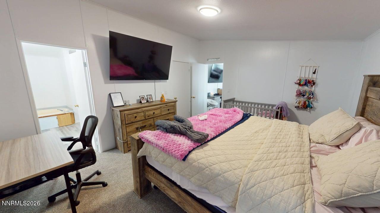 102 Bastian Road Battle Mountain, NV 89820 - Photo 23 of 38 a bedroom with a bed window tv and chair