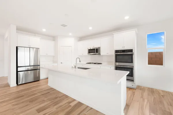 a kitchen with stainless steel appliances a refrigerator stove microwave and sink
