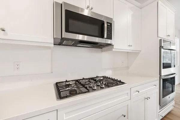 a kitchen with white cabinets and appliances