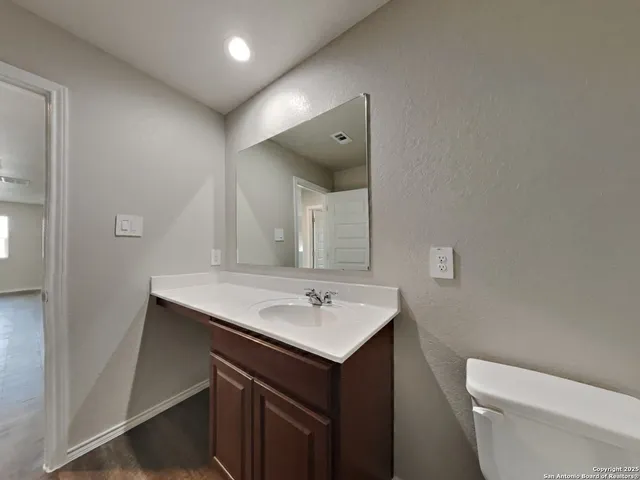 a bathroom with a sink toilet and mirror
