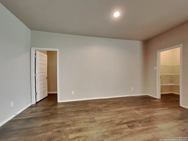 an empty room with wooden floor and closet