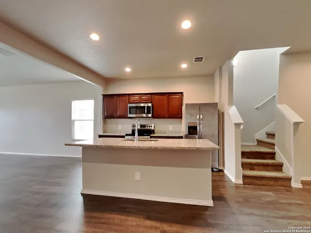 a view of a kitchen with furniture and wooden floor