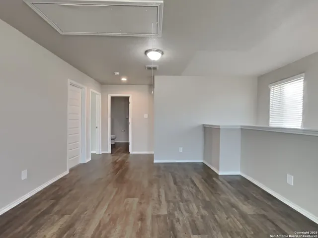 a view of empty room with wooden floor