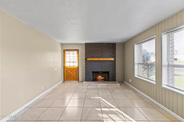 a view of an empty room with a fireplace and a window