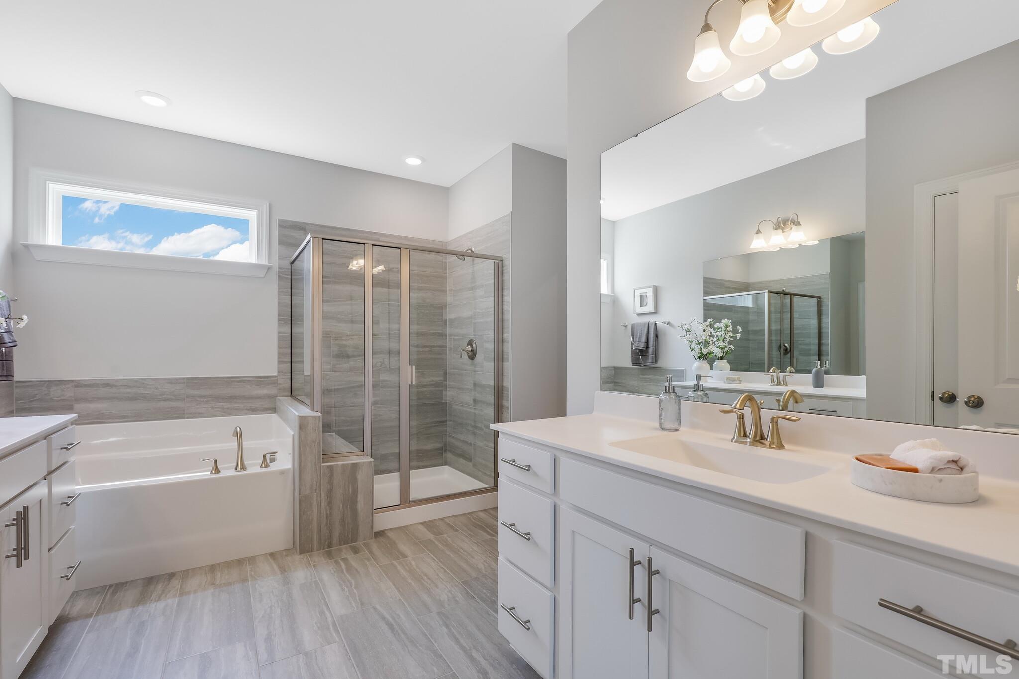 3937 Mount Moran Road Raleigh, NC 27616 - Photo 18 of 18 a bathroom with a tub a sink double vanity and mirror