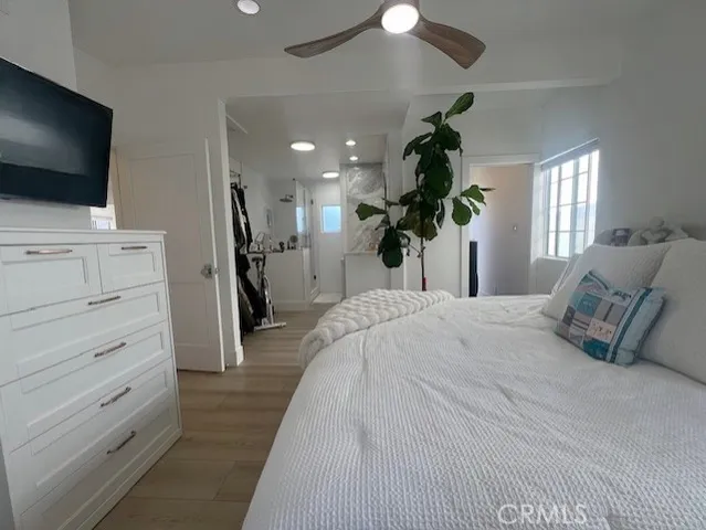 a bedroom with a bed a flat screen tv and a chandelier