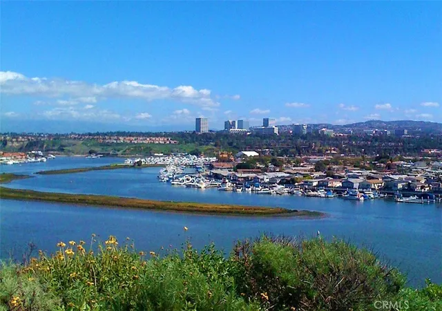a view of a city with lots of residential buildings ocean and mountain view in back