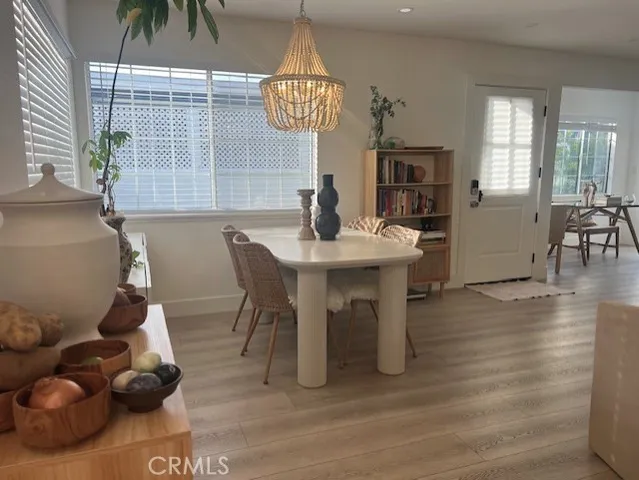 a view of dining room and livingroom with furniture wooden floor a rug a potted plant and a chandelier