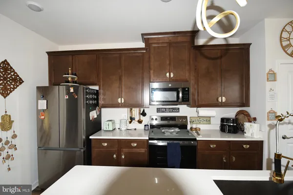 a kitchen with stainless steel appliances granite countertop a refrigerator a stove a sink and a microwave