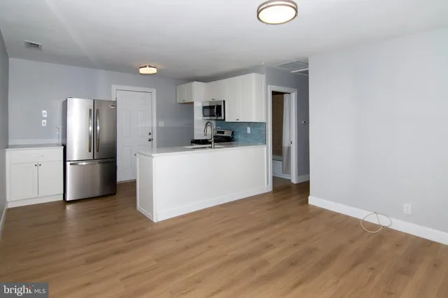 a kitchen with a refrigerator and a stove top oven