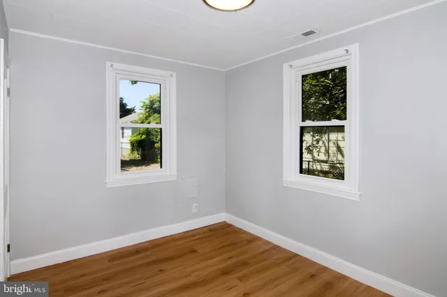 an empty room with window and wooden floor