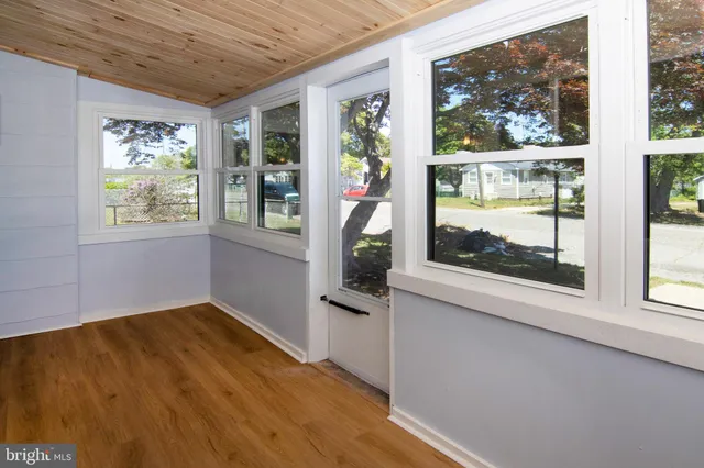 an empty room with wooden floor and a window