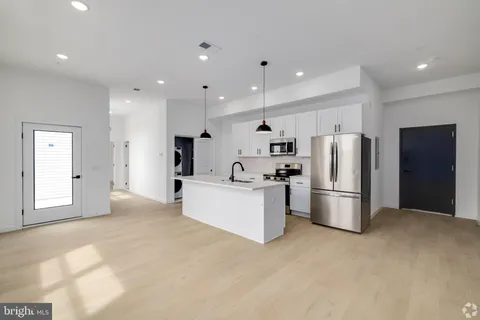 a kitchen with refrigerator and white cabinets