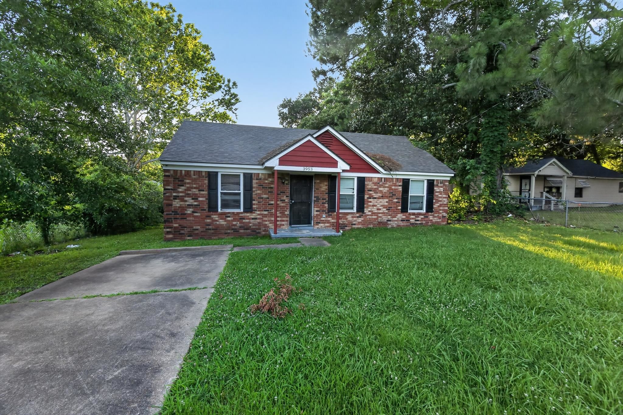 3953 McCain Road Memphis, TN 38109 - Photo 2 of 15 Brick facade home featuring a red-accented gable, black shutters, and a gray shingled roof