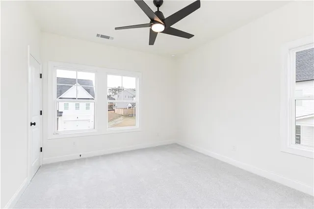 an empty room with a window and a fan