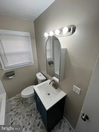 a bathroom with a sink toilet and mirror