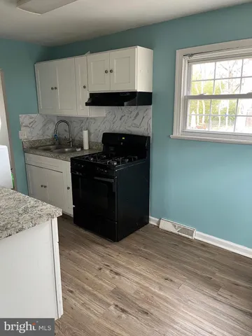 a kitchen with granite countertop wooden cabinets and a stove