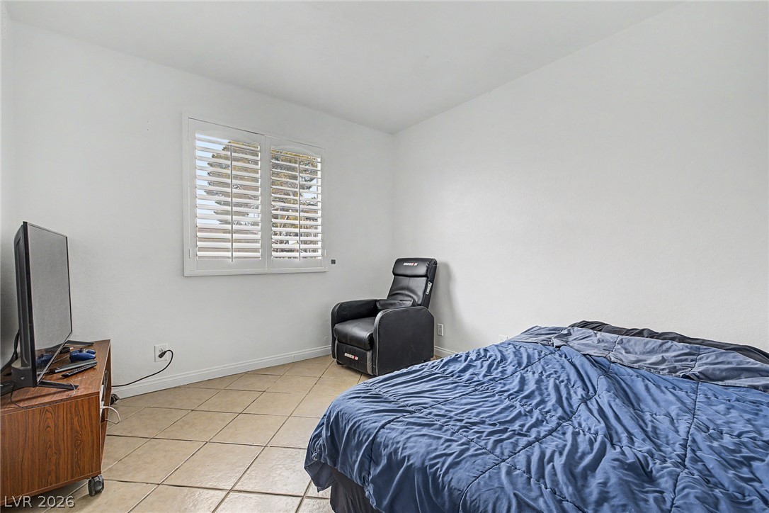 5357 Indian Wells Road Las Vegas, NV 89110 - Photo 24 of 39 The private bedroom offers cool tiled flooring and a sun-filled window with plantation shutters.