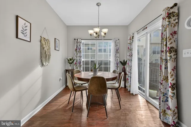 a dining room with furniture wooden floor and a chandelier
