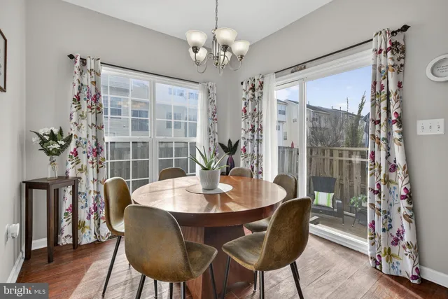 a kitchen with a stove a sink a microwave a dining table and chairs