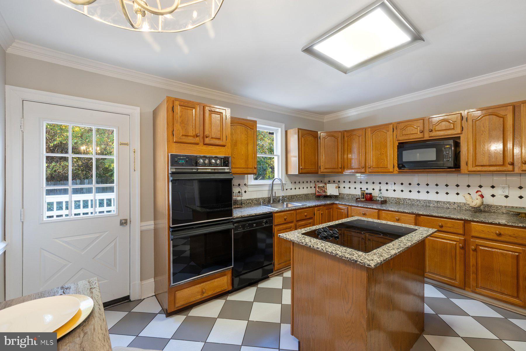 7005 Beacon Light Road Riverdale, MD 20737 - Photo 12 of 45 a kitchen with granite countertop stainless steel appliances a stove a sink and a microwave