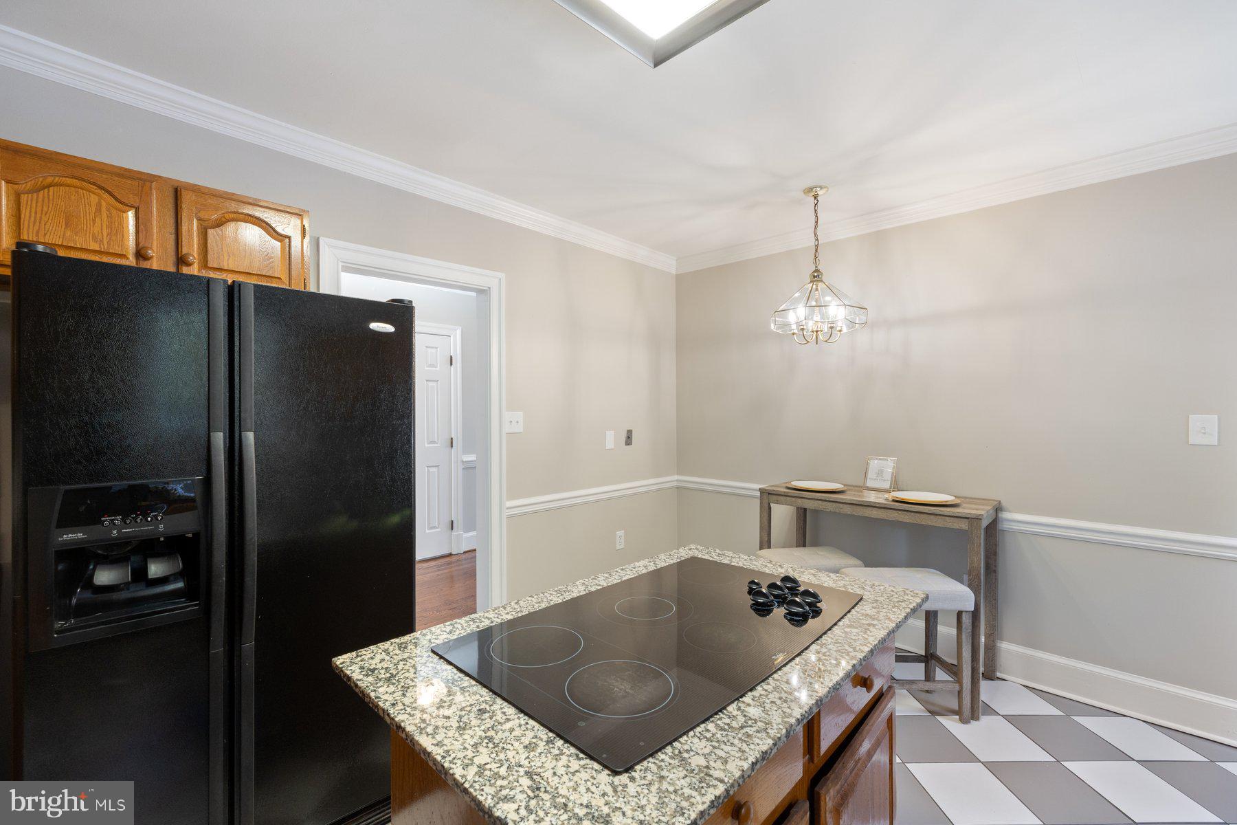 7005 Beacon Light Road Riverdale, MD 20737 - Photo 14 of 45 a kitchen with a table chairs and refrigerator