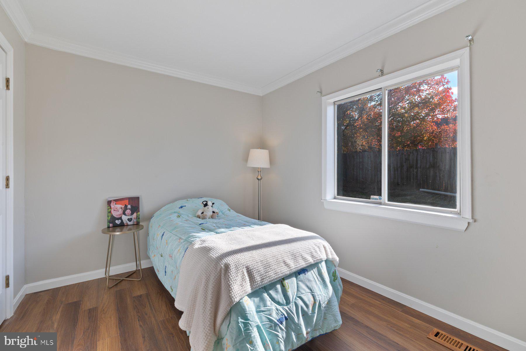 7005 Beacon Light Road Riverdale, MD 20737 - Photo 33 of 45 a bedroom with a bed and wooden floor