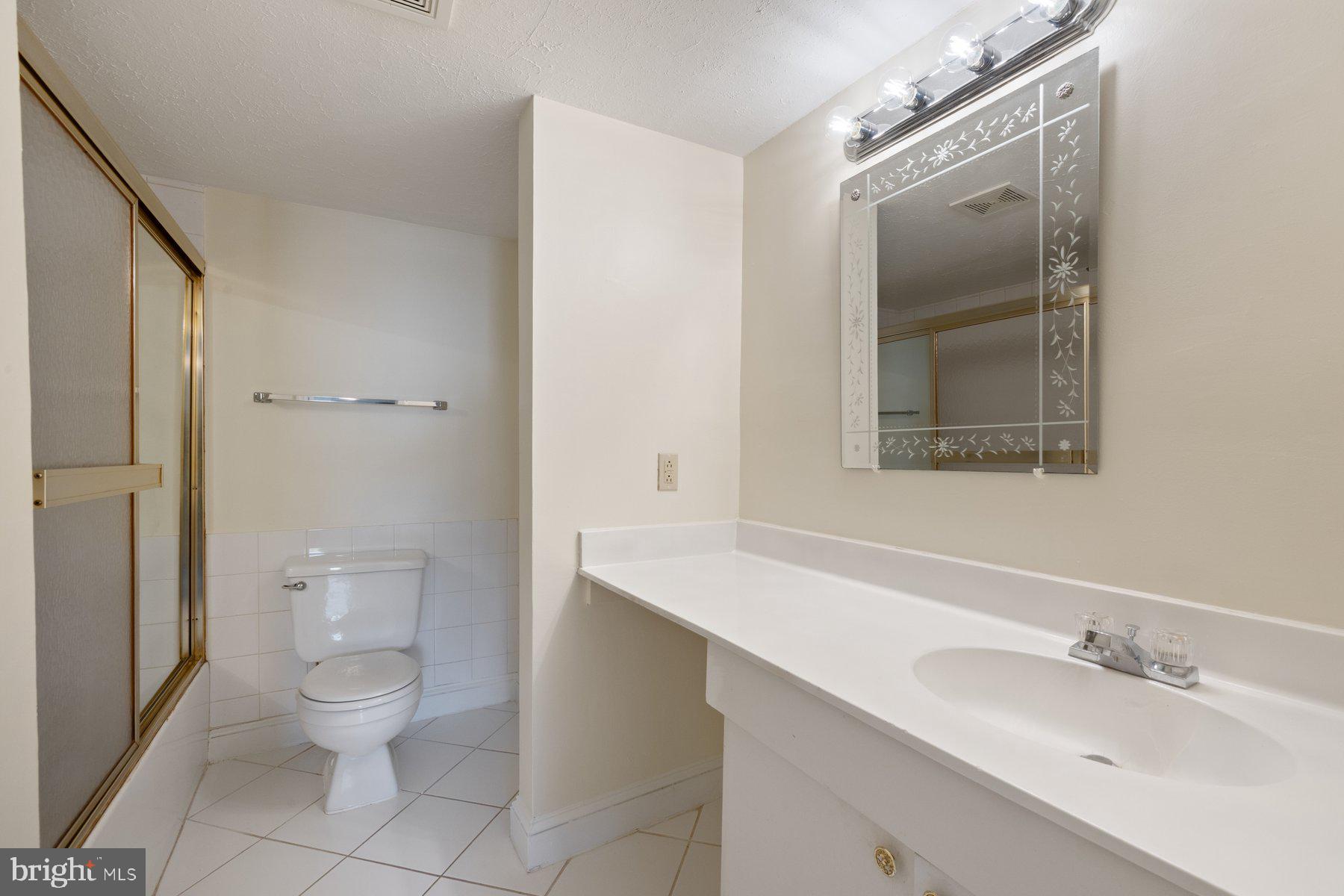 7005 Beacon Light Road Riverdale, MD 20737 - Photo 40 of 45 a bathroom with a toilet a sink a mirror and a shower