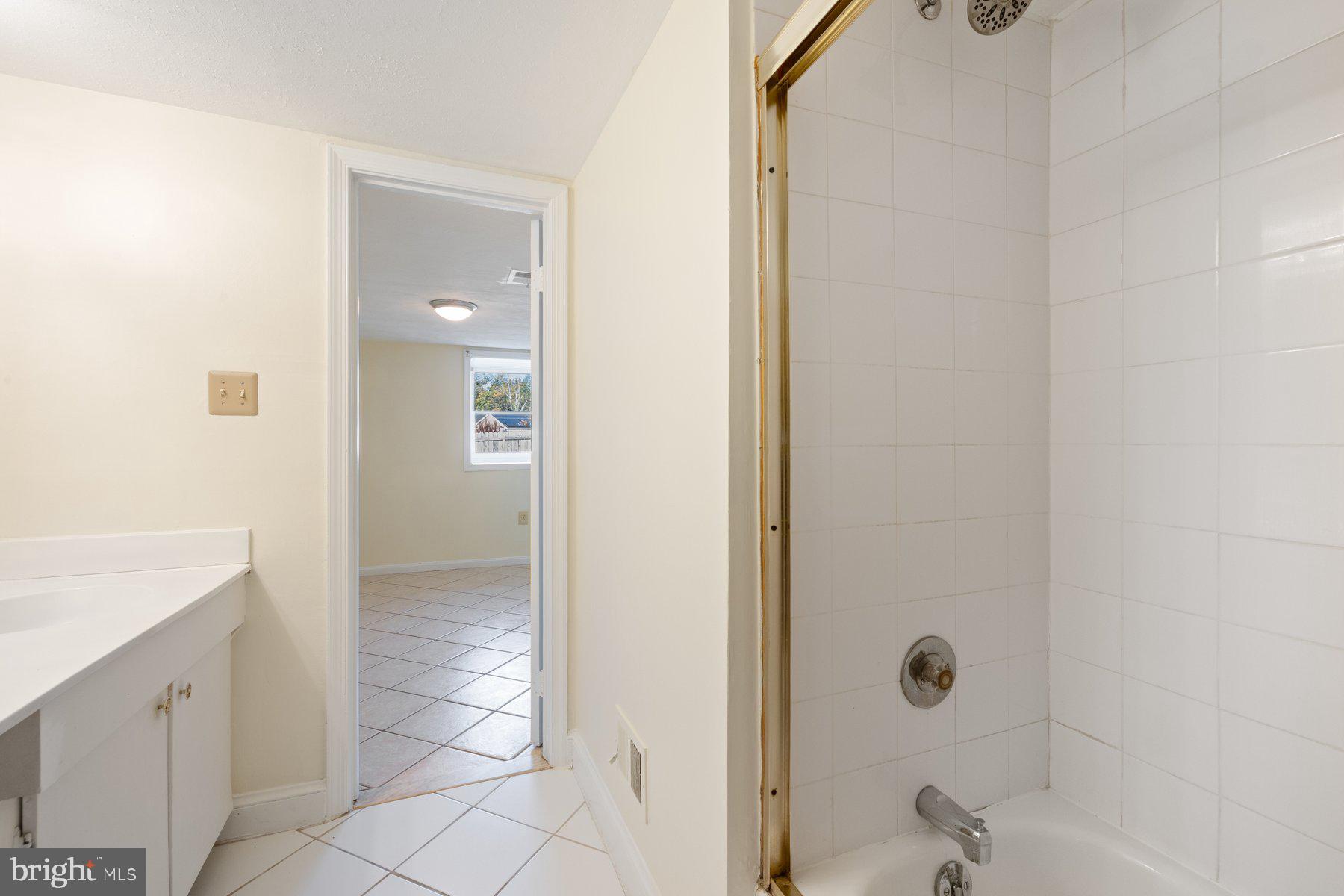 7005 Beacon Light Road Riverdale, MD 20737 - Photo 41 of 45 a bathroom with a granite countertop sink a mirror and shower