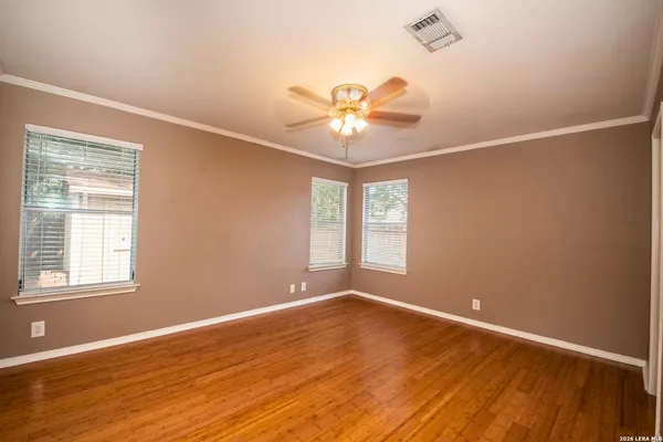 an empty room with wooden floor and windows