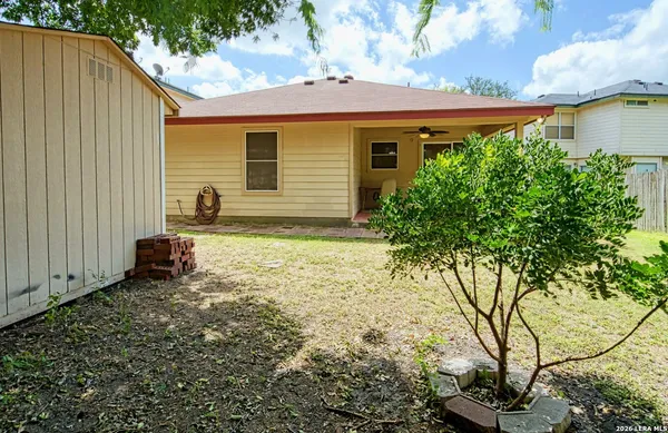 a view of a house with backyard and trees
