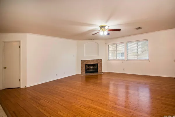 a view of empty room with wooden floor and fireplace