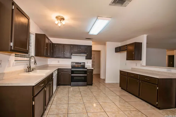 a kitchen with stainless steel appliances a sink stove and refrigerator