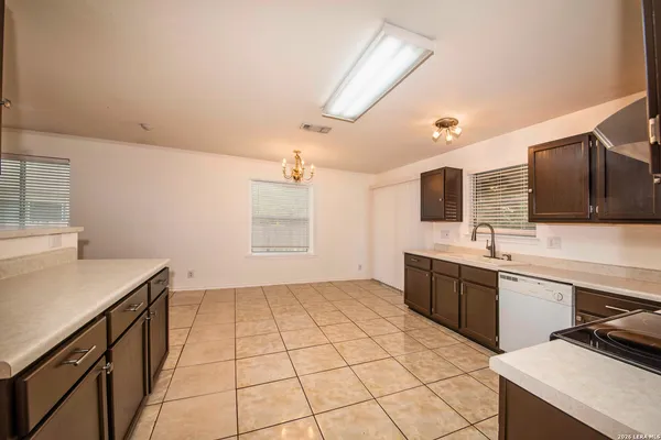 a large kitchen with stainless steel appliances a sink and cabinets