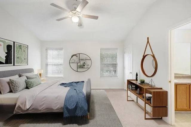 a bedroom with a bed a chandelier and a window
