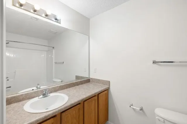 a bathroom with a granite countertop sink and a mirror