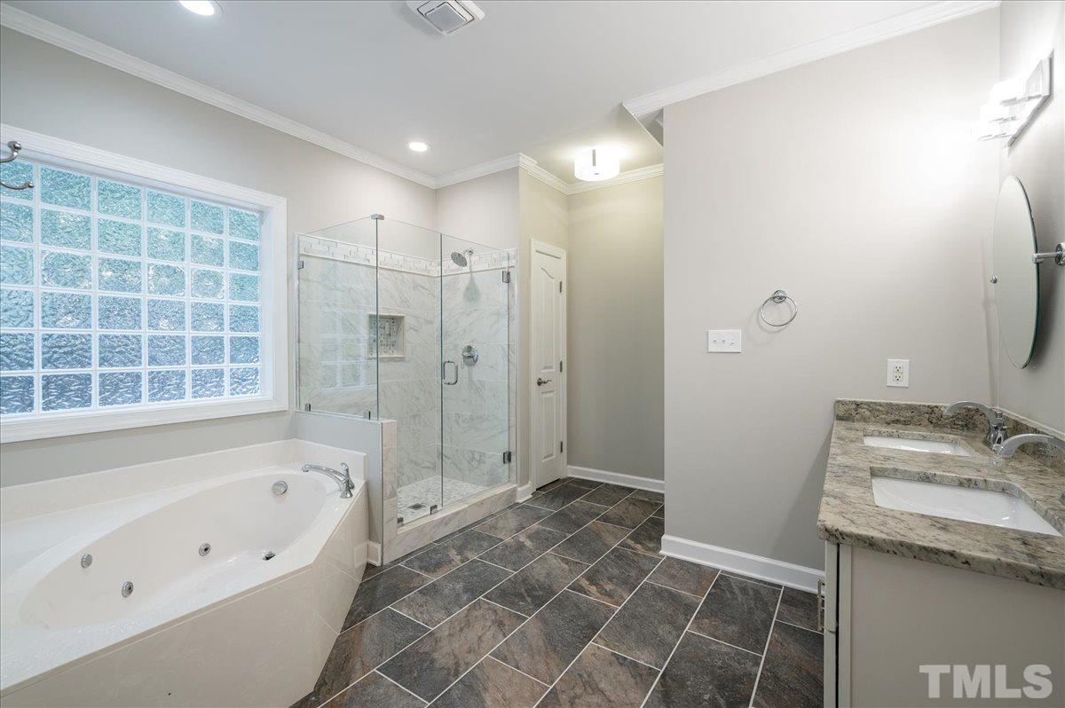 5245 Bartons Enclave Lane Raleigh, NC 27613 - Photo 12 of 27 Newly Updated Master Bath including tile floors, walk-in shower, dual vanity with granite countertops, modern mirrors and lighting. New toilet has motion sensor night light.