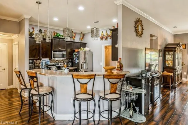 a dining area with stainless steel appliances kitchen island granite countertop a table and chairs