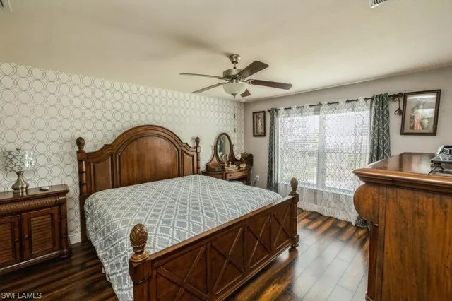 a bedroom with a bed and a table with wooden floor